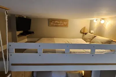 a bedroom with a white bed with a tv at Bright studio apartment with terrace in Cannes in Cannes