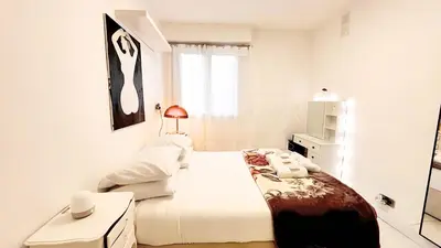 a white bedroom with a white bed and a window at Proche Centre ville, 1 chambre, balcon - Palmazur Vacances in Le Cannet