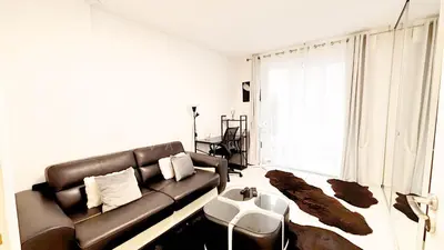 a living room with a leather couch and a large window at Proche Centre ville, 1 chambre, balcon - Palmazur Vacances in Le Cannet
