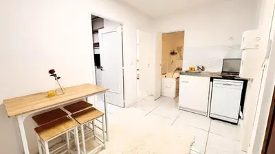 a kitchen with white appliances and a wooden table at Proche Centre ville, 1 chambre, balcon - Palmazur Vacances in Le Cannet