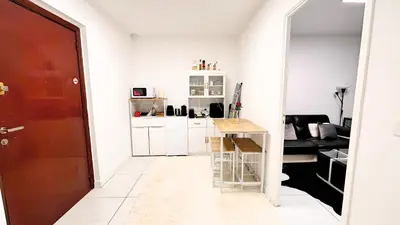 a small white kitchen with a table in a room at Proche Centre ville, 1 chambre, balcon - Palmazur Vacances in Le Cannet