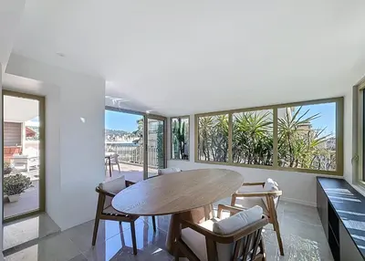 a dining room with a table and chairs and windows at New Modern rooftop 2 ch 4 peoples Clim Wifi in Le Cannet