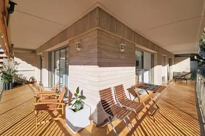 a deck with chairs and a building with windows at HENRI CAMILLE RE -Wios- 2 bedrooms APT - Huge terrace sea view in Cannes