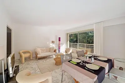 a living room with a table and chairs and a living room at HENRI CAMILLE RE -Wios- 2 bedrooms APT - Huge terrace sea view in Cannes