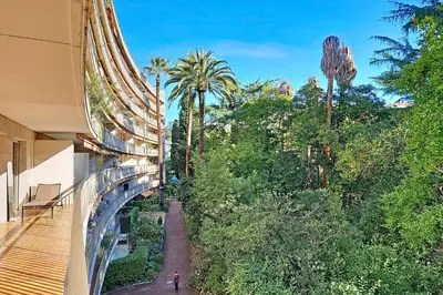 a person walking down a walkway next to a building at HENRI CAMILLE RE -Wios- 2 bedrooms APT - Huge terrace sea view in Cannes