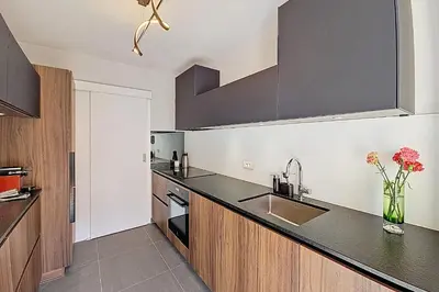 a kitchen with black countertops and a sink at HENRI CAMILLE RE -Wios- 2 bedrooms APT - Huge terrace sea view in Cannes