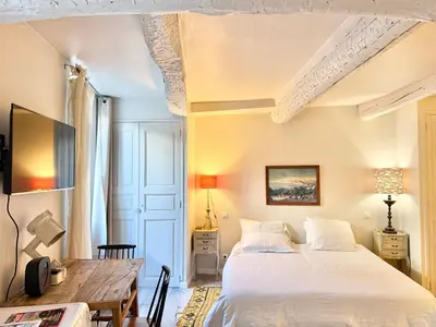 a bedroom with a large bed and a table at Elegant studio à Cannes - Suquet - 2 people in Cannes
