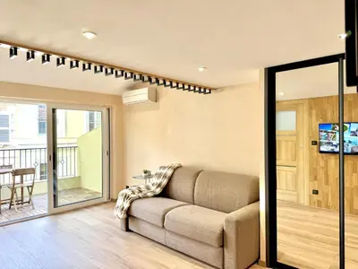 a living room with a couch and a balcony at Top floor apartment in Cannes