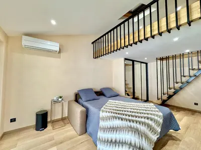 a bedroom with a blue bed and a staircase at Top floor apartment in Cannes