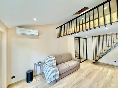 a living room with a couch and a staircase at Top floor apartment in Cannes