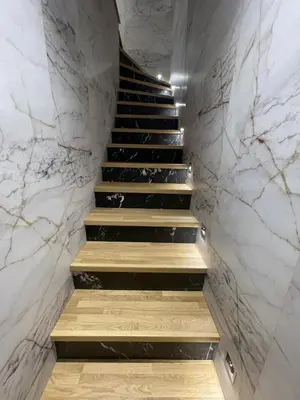 a staircase with marble walls and wooden steps at Top floor apartment in Cannes