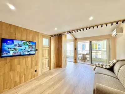 a living room with a couch and a tv on a wall at Top floor apartment in Cannes