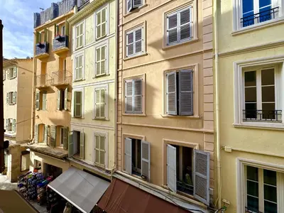 a tall building with windows and an awning in front at Suquet apartment cosy et charming in Cannes