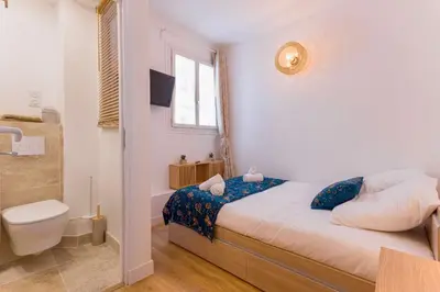 a small bedroom with a bed and a toilet at Azur Loft Beauséjour Heart of Cannes in Cannes