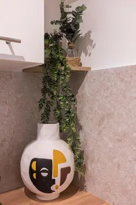 a white vase with a cat on it next to a plant at Azur Loft Beauséjour Heart of Cannes in Cannes
