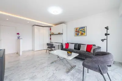 a living room with a couch and a table at Studio in a Prestigious Residence Close to the City Centre in Cannes