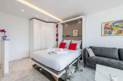 a small bedroom with a bed and a couch at Studio in a Prestigious Residence Close to the City Centre in Cannes