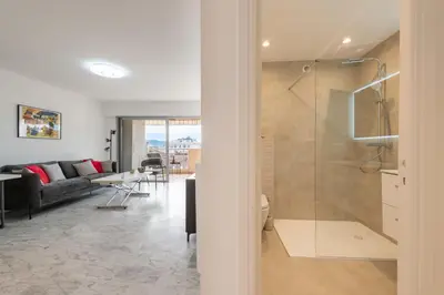a living room with a glass shower and a couch at Studio in a Prestigious Residence Close to the City Centre in Cannes