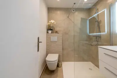 a bathroom with a toilet and a glass shower at Studio in a Prestigious Residence Close to the City Centre in Cannes