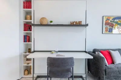 a desk and a chair next to a book shelf at Studio in a Prestigious Residence Close to the City Centre in Cannes