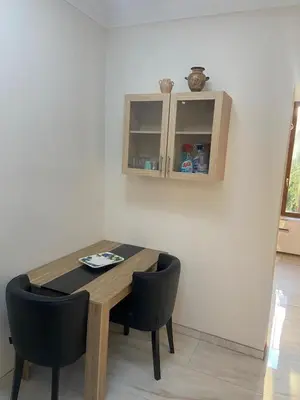 a dining room table with two chairs and a cabinet at Studio climatisé 5 min centre Cannes in Cannes