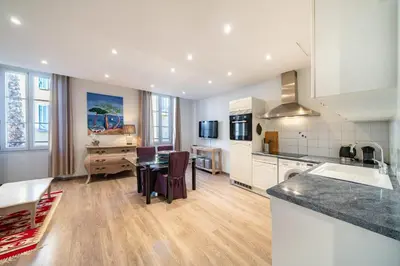 a kitchen and living room with a table and chairs at Cozystay 1802 One bedroom in the Heart of Cannes in Cannes