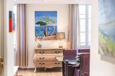a room with a desk and a painting on the wall at Cozystay 1802 One bedroom in the Heart of Cannes in Cannes
