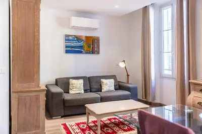 a living room with a couch and a table at Cozystay 1802 One bedroom in the Heart of Cannes in Cannes