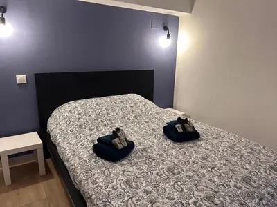 two people sitting on a bed in a bedroom at Superbe 4P, 3 Ch, 2 SDB, Proche Palais et Plages in Cannes