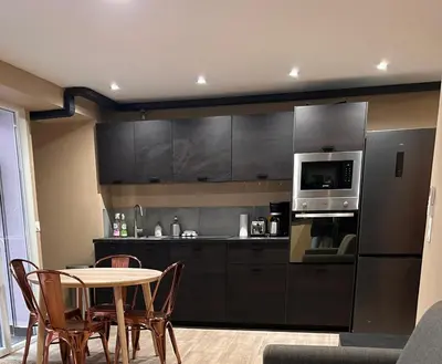 a living room with a couch and a table and a kitchen at Superbe 4P, 3 Ch, 2 SDB, Proche Palais et Plages in Cannes