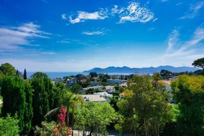 a city with trees and the ocean in the background at Ref JOA - Palmes d Or Properties in Cannes