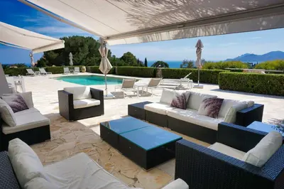 a patio with couches and chairs next to a pool at Ref JOA - Palmes d Or Properties in Cannes