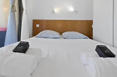 a white bed with two bunks on top of it at Le RivieraPeacefulSwimming poolCar parkSeafront in Cannes