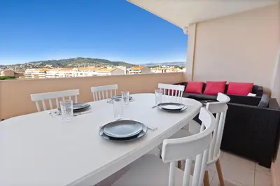 a white table with white chairs and a balcony at Le RivieraPeacefulSwimming poolCar parkSeafront in Cannes
