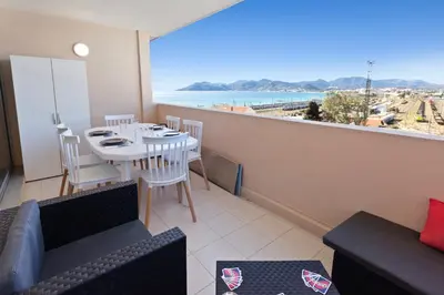 a living room with a table and a view of the ocean at Le RivieraPeacefulSwimming poolCar parkSeafront in Cannes
