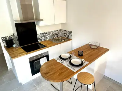 a living room with a table and a couch at Studio BELLA VISTA avec parking in Le Cannet