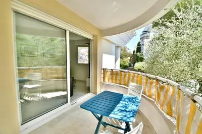 a balcony with a table and chairs on a railing at Studio BELLA VISTA avec parking in Le Cannet