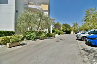 a parking lot with cars parked in front of a building at Studio BELLA VISTA avec parking in Le Cannet