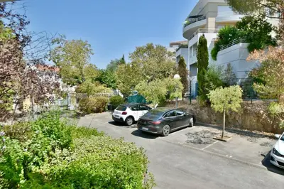 two cars parked in a parking lot in front of a building at Studio BELLA VISTA avec parking in Le Cannet