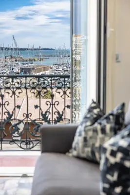 a couch in front of a window with a view of a marina at 2 chambres-BALCON-VUE MER-FELIX FAURE A2B231 in Cannes