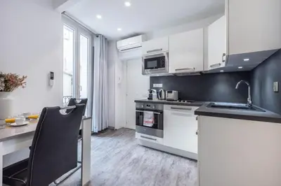 a kitchen with white cabinets and a sink and a counter at 2 pièces Moderne FELIX FAURE-VIEUX PORT A1B232 in Cannes