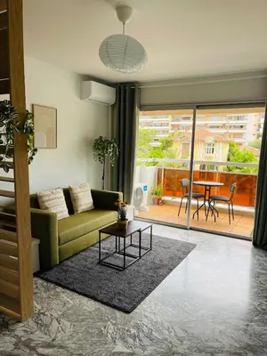 a living room with a couch and a table at Charmant studio en centre ville in Le Cannet