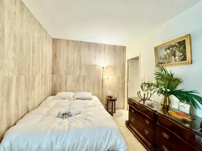 a bedroom with a large bed and a wooden wall at Gray studio D vue mer in Cannes