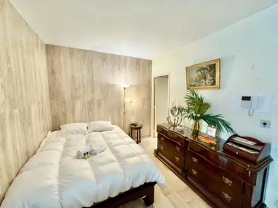 a bedroom with a large white bed and a dresser at Gray studio D vue mer in Cannes