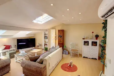 a living room with a couch and a tv at HENRI CAMILLE REAL ESTATE - ROOF - 2 bedrooms downtown w rooftop in Cannes
