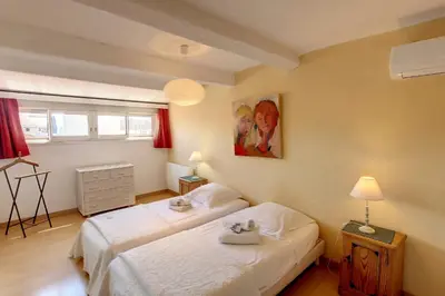 a bedroom with two beds and a painting on the wall at HENRI CAMILLE REAL ESTATE - ROOF - 2 bedrooms downtown w rooftop in Cannes