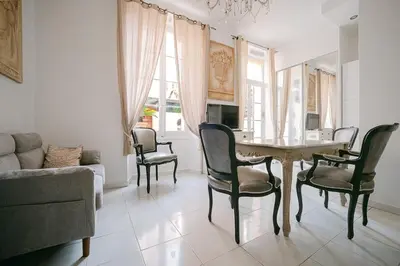 a living room with a table and chairs and a couch at Le Petit Palais, 100m des plages in Cannes