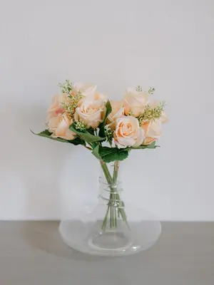 a glass vase filled with pink roses on a table at Le Petit Palais, 100m des plages in Cannes