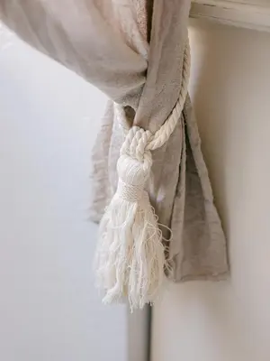 a curtain with a white tassel on a window at Le Petit Palais, 100m des plages in Cannes
