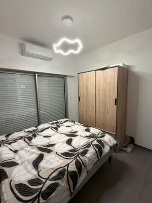 a bedroom with a bed and a wooden cabinet at Superbe Appartement 2 pièces - 39m2 in Cannes